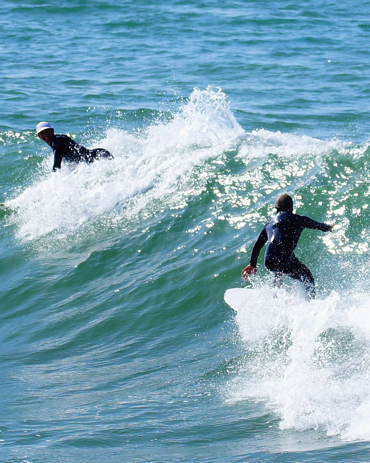Coaching de surf privé à Taghazout : un surfeur sur la vague, un second à l'eau juste derrière