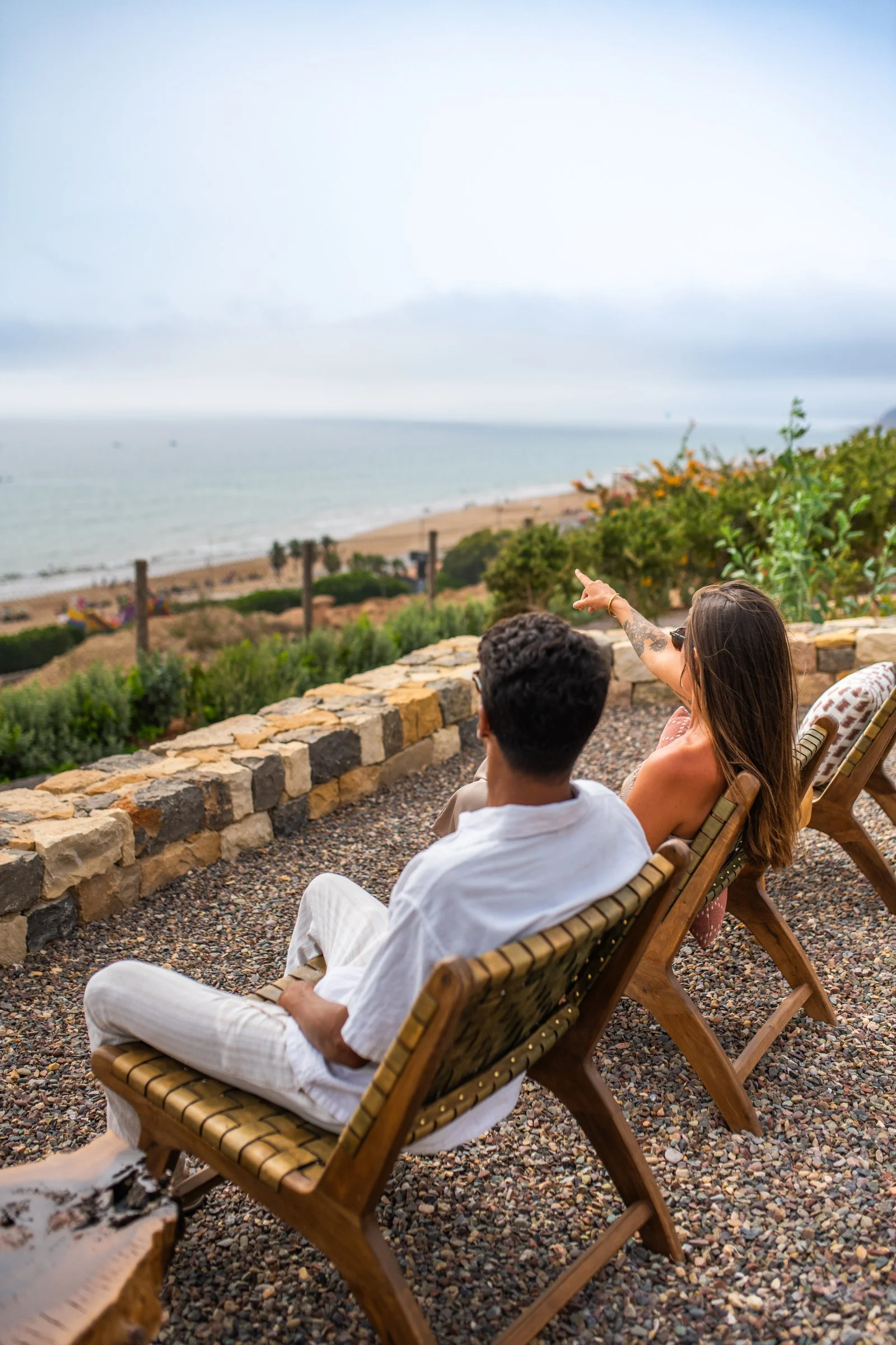 Un couple assis sur la terrasse d'Amanblu, face à la baie et à la plage de Taghazout